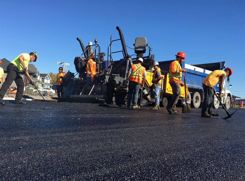 Une équipe effectuant l'excavation et le pavage d'asphalte sur une rue